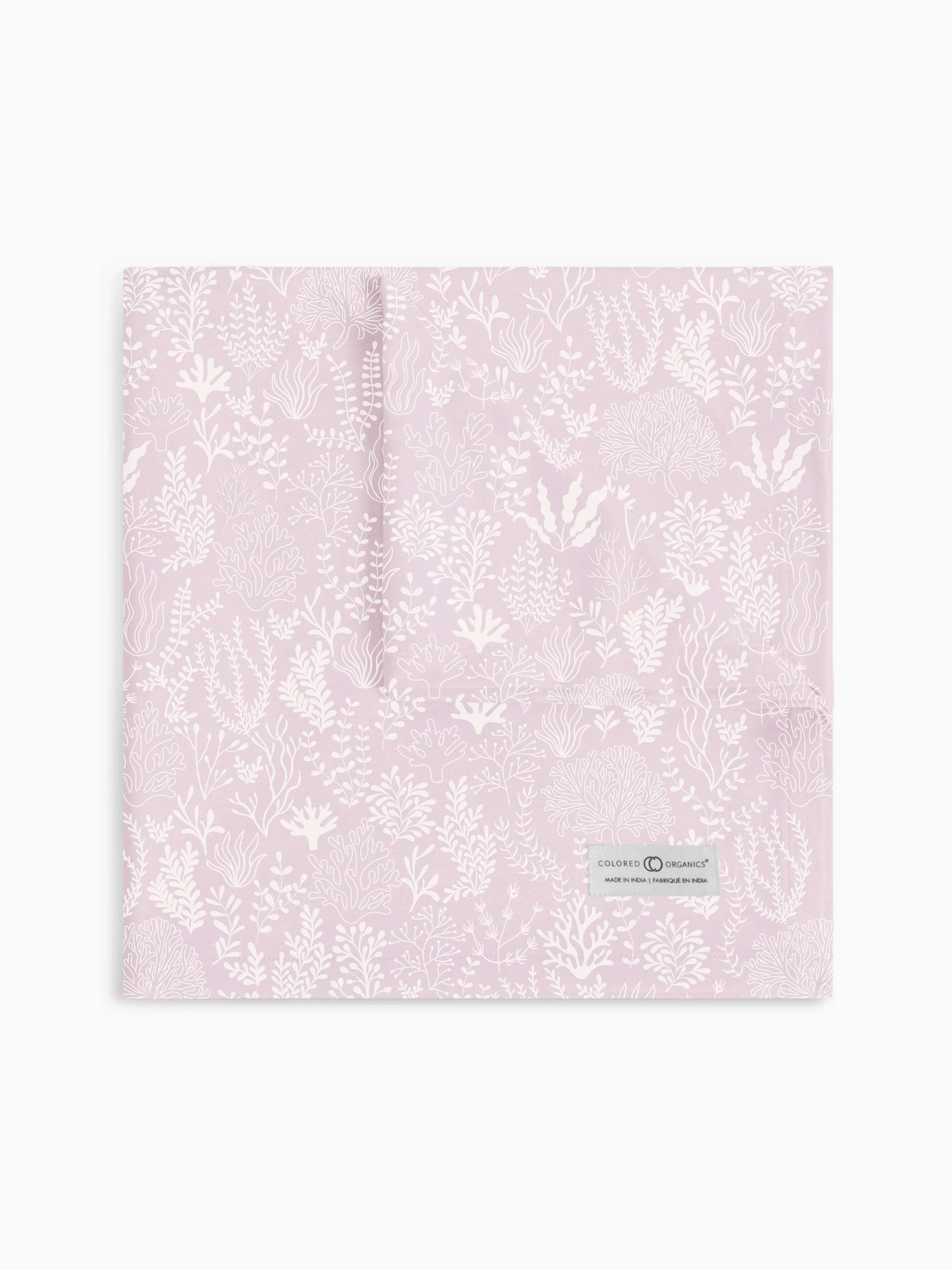 Colored Organics swaddle blanket in 'Coral Reef - Wisteria' design, beautifully laid out to display a detailed coral pattern in a delicate wisteria purple hue, featuring the brand's signature organic label