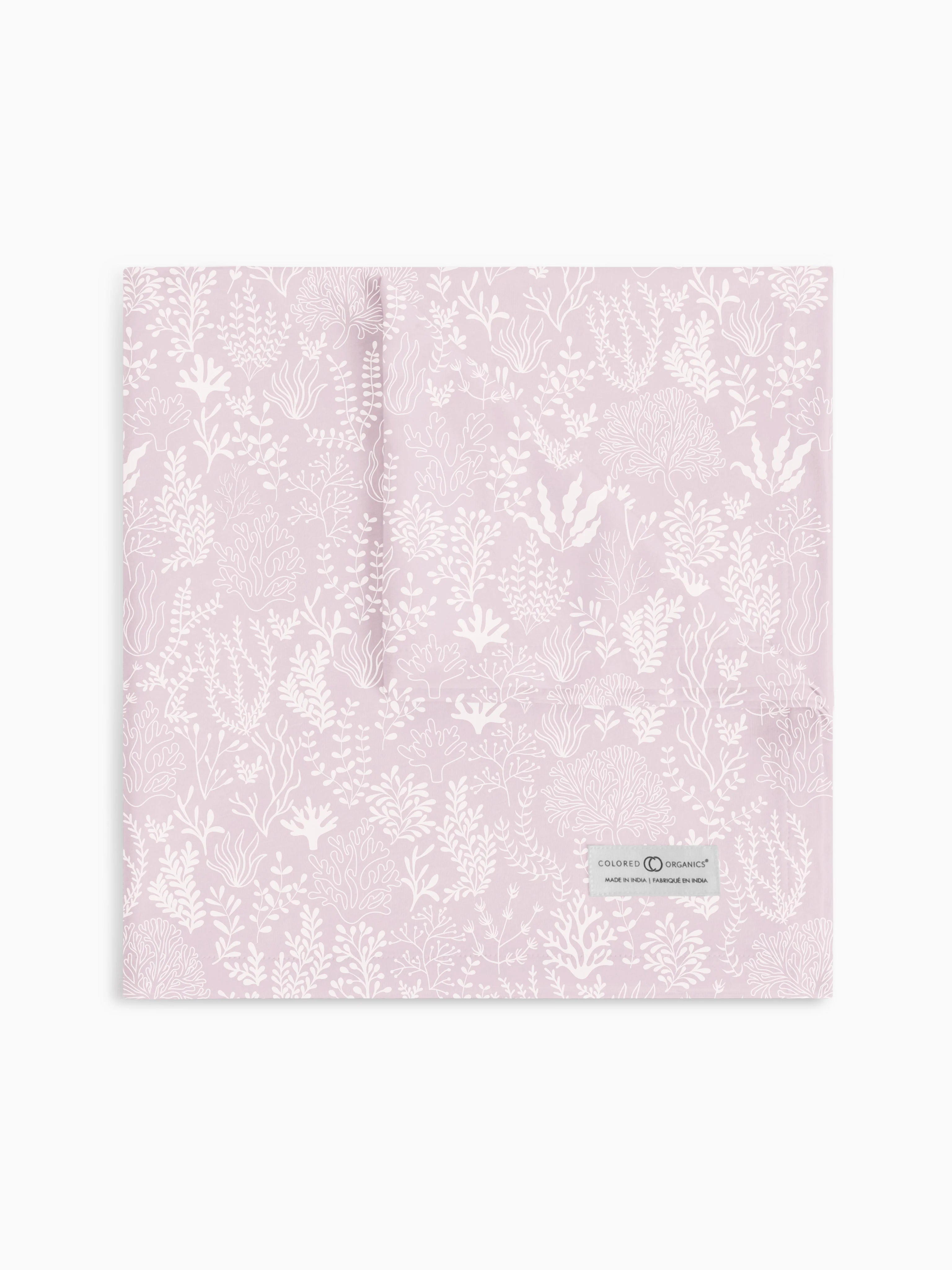 Colored Organics swaddle blanket in 'Coral Reef - Wisteria' design, beautifully laid out to display a detailed coral pattern in a delicate wisteria purple hue, featuring the brand's signature organic label